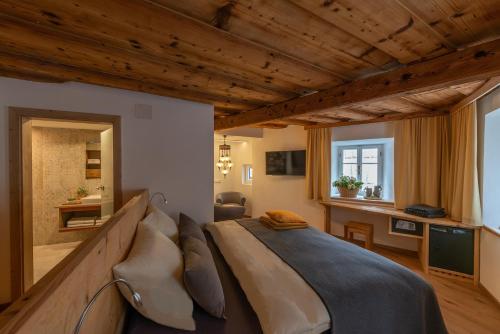 a large bed in a room with wooden ceilings at I da Mitt in Hallstatt