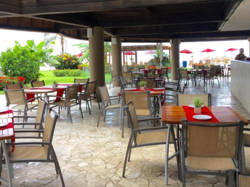 an outdoor restaurant with tables and chairs with red napkins at Apartamentos Grand Venetian Puerto Vallarta in Puerto Vallarta