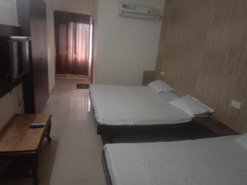 1 dormitorio con 2 camas y pared de madera en HOTEL JOGI GUEST HOUSE, en Amritsar