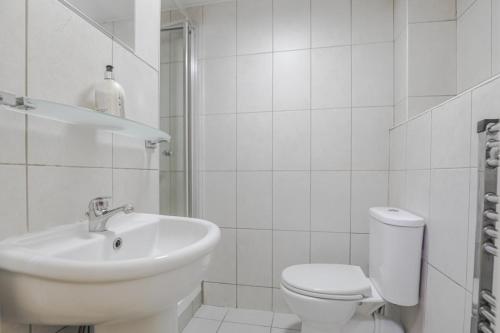 a white bathroom with a sink and a toilet at Sangha House in Leicester