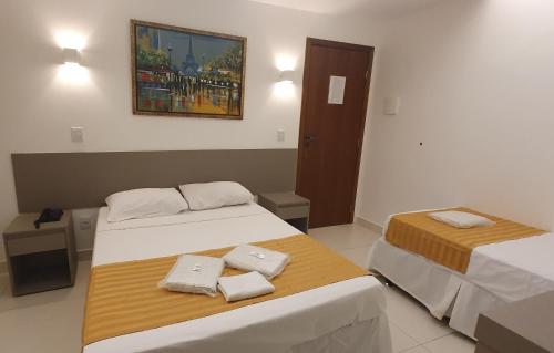 a room with two beds with towels on them at Hotel Hellyus in Brasilia