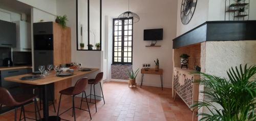 um quarto com uma mesa e cadeiras e uma lareira em Appartement Duplex au Coeur du Centre Historique em Bergerac