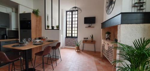une pièce avec une table, des chaises et une cheminée dans l'établissement Appartement Duplex au Coeur du Centre Historique, à Bergerac