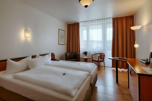 a hotel room with a large bed and a desk at Comfort Hotel Bernau in Bernau bei Berlin