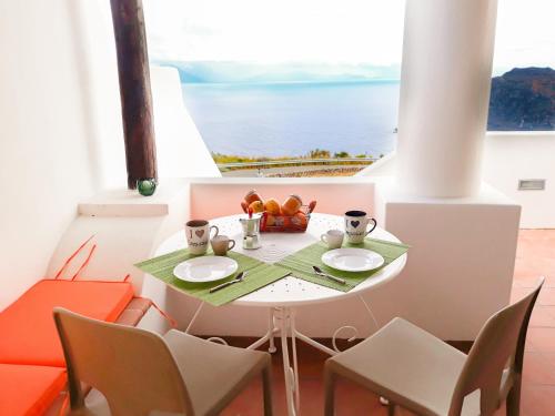 a small table with two plates and a bowl of fruit at Residence Gregory Filicudi in Filicudi