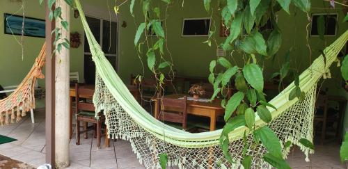 - un hamac dans un restaurant avec une table et des chaises dans l'établissement Pousada Conquista do Paraíso, à Alto Paraíso de Goiás