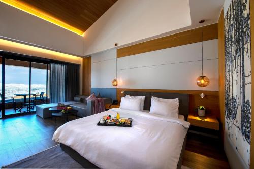 a bedroom with a large bed and a living room at Oakridge Hotel & Spa in Kfardebian