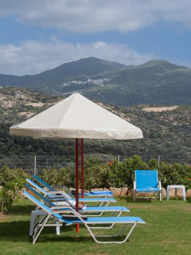 a group of lawn chairs and an umbrella at Triopetra Luxury Villas Fournou Lago in Triopetra