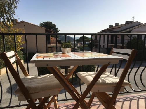 une table et deux chaises sur un balcon dans l'établissement Studio L’ARGENTIERE PLAGE, à La Londe-les-Maures