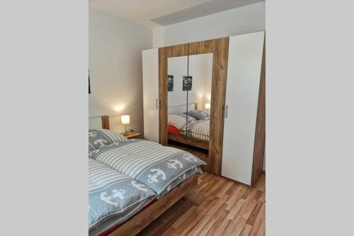 Schlafzimmer mit einem Bett und einem Spiegel in der Unterkunft Ingrid`s Ferienwohnung in Röthenbach an der Pegnitz