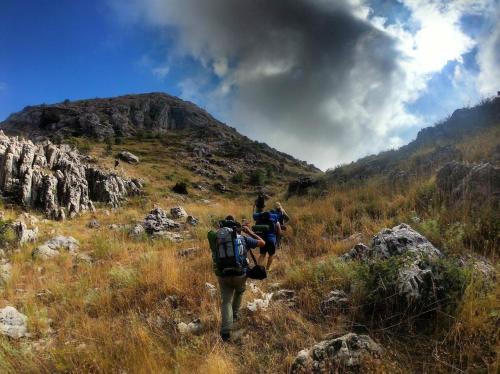 a group of people walking on a mountain trail at Stone Cellars in Douma
