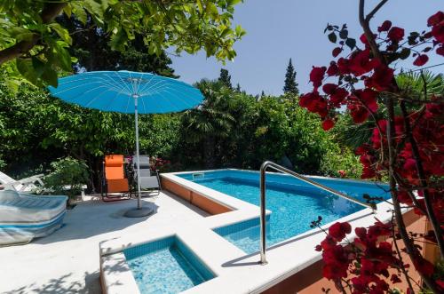 una piscina con sombrilla junto a una piscina en Villa Gemma, en Mlini