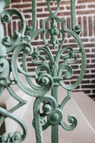 a green metal gate in front of a building at Penzion U Kubesa - Adults only in Kroměříž