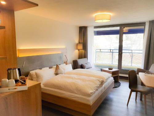 a hotel room with a large bed and a desk at Hotel Graf Eberhard in Bad Urach