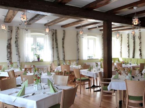 a dining room with white tables and chairs and windows at Zum Alten Hafen in Rathenow