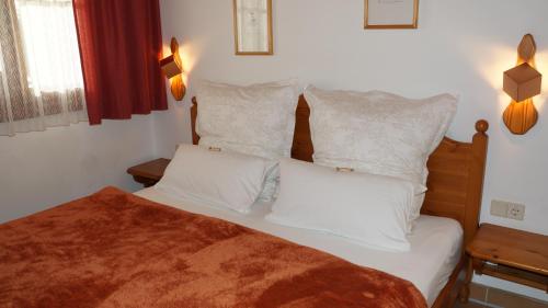 a bedroom with a bed with white sheets and pillows at Gerlitzen, Gerlitzen Alpe, Residenz Kanzelhöhe, Ossiacher See in Treffen