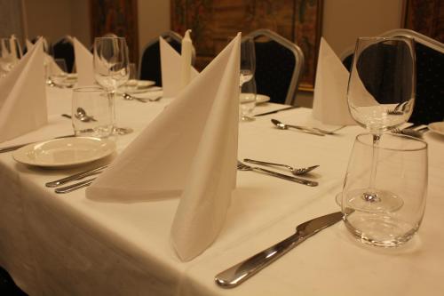 a table with white napkins and wine glasses on it at Henriks Hotell in Skien