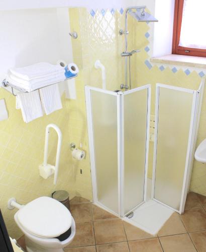 a bathroom with a toilet and a shower at BUE MARINO Hotel & Roof Lounge in Cala Gonone