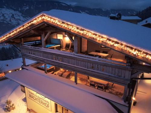 a house with lights on the roof in the snow at Chalets & Apartments Wachterhof in Kaltenbach