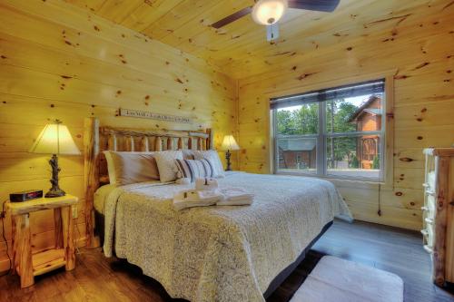 a bedroom with a bed in a log cabin at Luxury 5bed/6ba Cabin: Theater, Pool Room, Hottub! in Gatlinburg