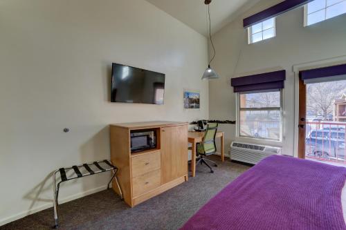 a bedroom with a tv on the wall and a desk at The Gonzo Inn in Moab