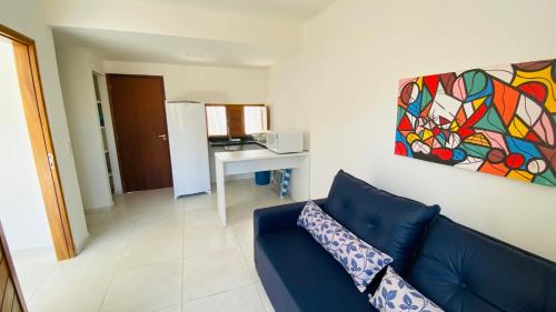 a living room with a blue couch and a table at Condomínio Villa dos Corais in Maragogi