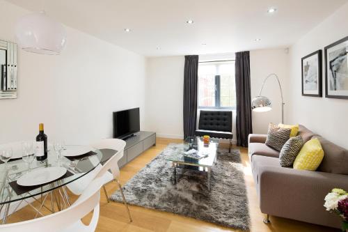 a living room with a couch and a table at Cambric by Aeria Apartments in London