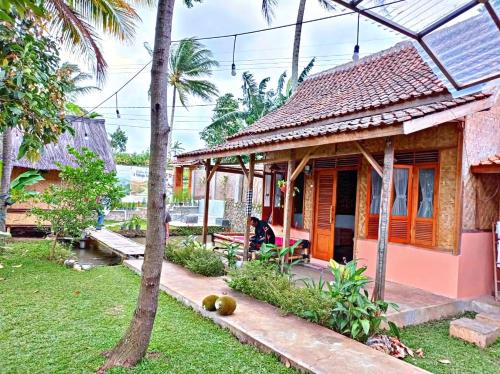 a house with a person sitting outside of it at Paddies Homestay New in Cipaku-gede