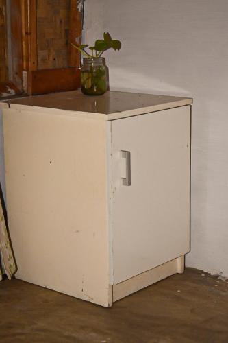 a white cabinet with a plant on top of it at Paddies Homestay New in Cipaku-gede