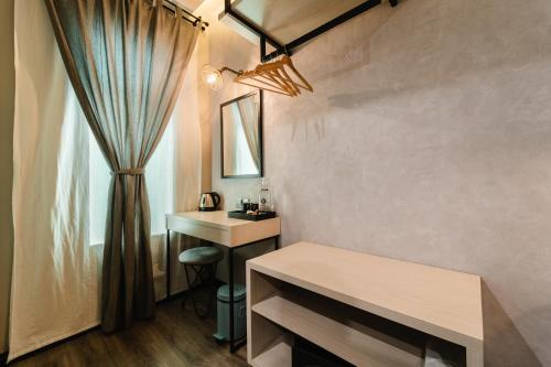 a room with a desk and a mirror and a window at SVOK Hotel in Tawau