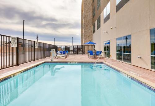 a swimming pool with chairs and a building at Holiday Inn Express - Kermit by IHG in Kermit
