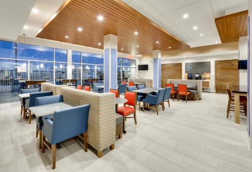 a dining room with tables and chairs and windows at Holiday Inn Express - Kermit by IHG in Kermit