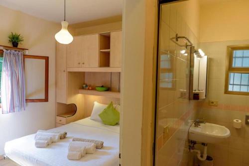 a bathroom with a bed and a sink and a shower at Arco Bungalow in Eraclea Mare