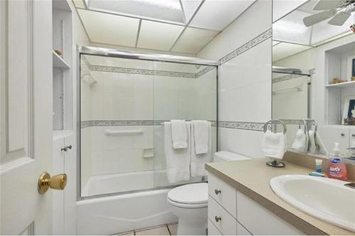 a bathroom with a shower and a toilet and a sink at Siesta Key Escape Ground Floor Steps to Heated Pool and Free Trolley in Siesta Key