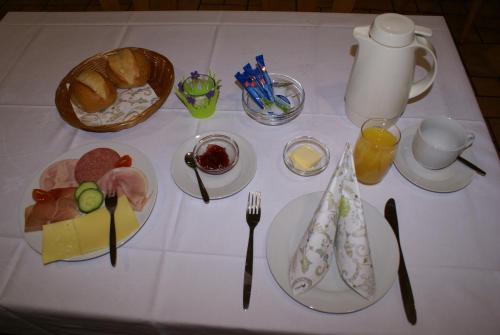 a white table topped with plates of food and drinks at Pension Lindenhof in Limburg an der Lahn