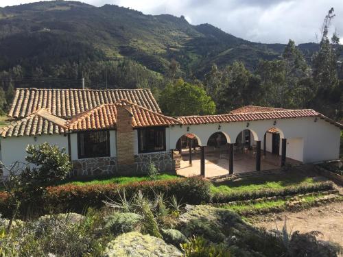 a house with a mountain in the background at La Casona Cucaita. Sede Campestre in Cucaita