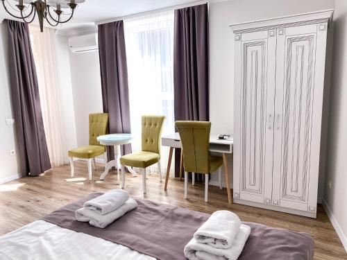 una camera con letto, tavolo e sedie di Opera Center Hotel & Apartments a Lviv