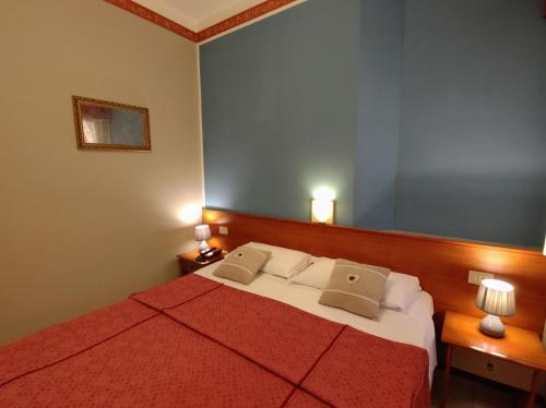 a bedroom with a large bed with two pillows at Hotel Minerva in Ravenna