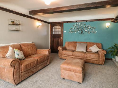 a living room with two brown couches and a couch at Fields Farm in Draycott in the Moors