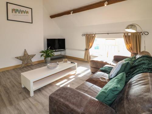 a living room with a couch and a coffee table at Fields Farm in Draycott in the Moors