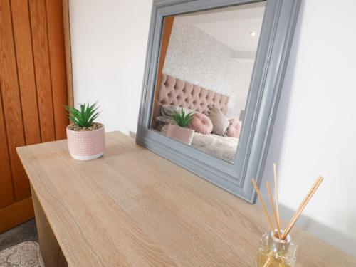 a mirror sitting on top of a table in front of a dresser at Fields Farm in Draycott in the Moors