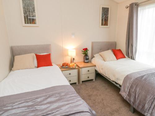 a bedroom with two beds and a table with a window at Huckleberry in Saltburn-by-the-Sea