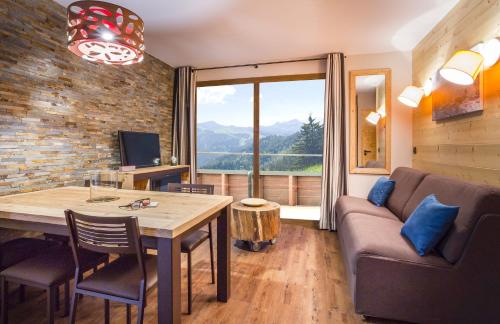 a living room with a table and a couch at Résidence Club MMV L'Altaviva in Tignes