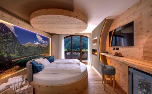 sypialnia z łóżkiem w pokoju z telewizorem w obiekcie Kristiania Pure Nature Hotel & Spa w mieście Cogolo