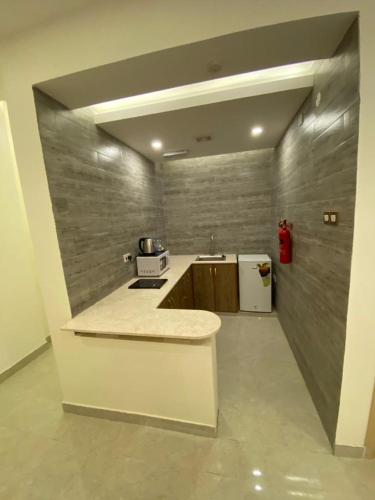 a kitchen with a counter and a sink in a room at فندق المستقبل للشقق الفندقية ALMUSTAQBAL HOTEL Apartments in Ibrā