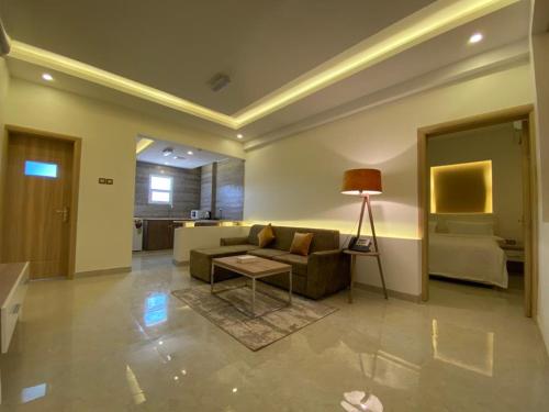 a living room with a couch and a table at فندق المستقبل للشقق الفندقية ALMUSTAQBAL HOTEL Apartments in Ibrā