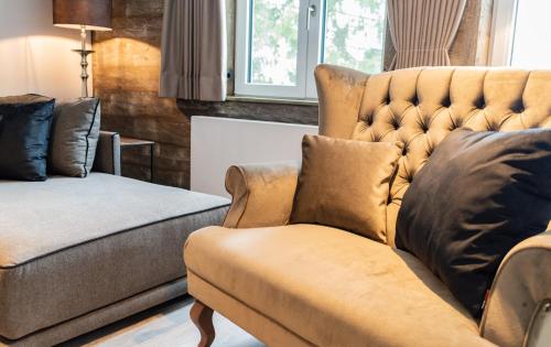 a living room with a couch and a chair at StrandBerg's Ursprung: Spa & Kitchen in Braunlage