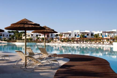 - un groupe de chaises longues et de parasols à côté de la piscine dans l'établissement I Turchesi Club Village, à Castellaneta Marina