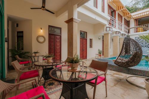 a patio with tables and chairs and a pool at Hotel Boutique Casa Sánchez in Santo Domingo