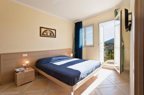 ein Schlafzimmer mit einem Bett und einem Balkon in der Unterkunft Posidonia Residence in Ischia